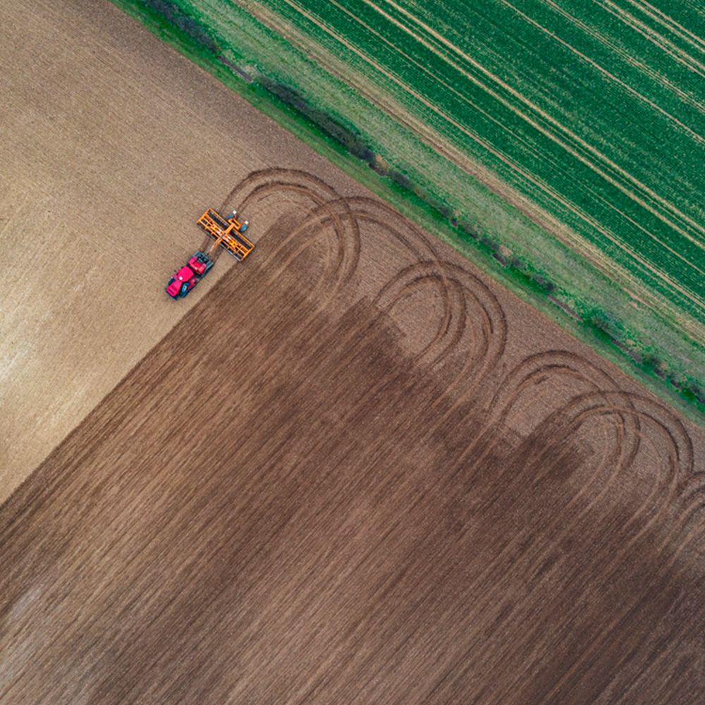 Drone view of tractor ploughing a field