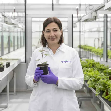 Camilla Corsi in greenhouse holding plant
