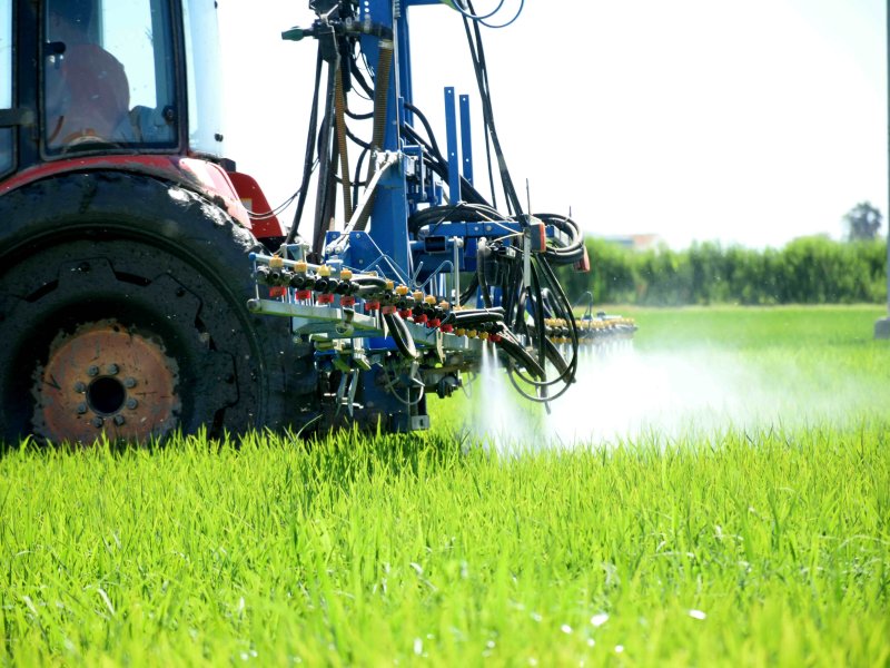Tractor and spray boom in a rice field