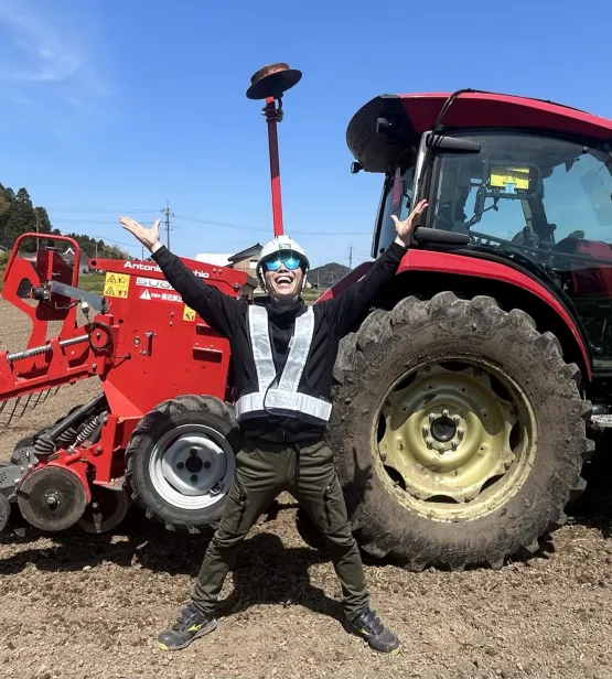 Farmer Tokumoto standing in front of of his tractor, Japan