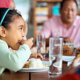 Girl having rice with family at home.png