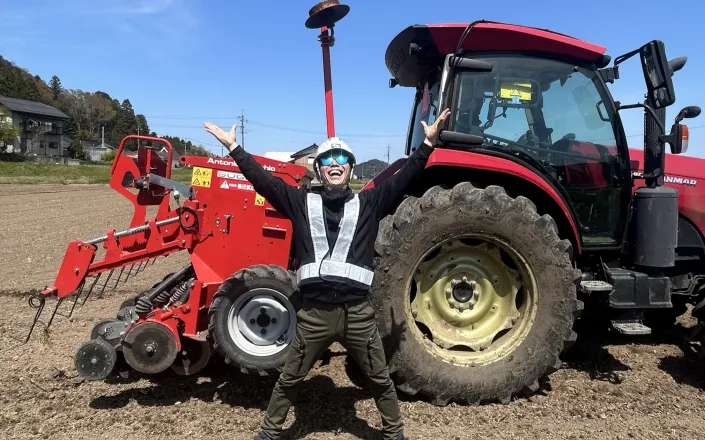 Farmer Tokumoto standing in front of of his tractor, Japan
