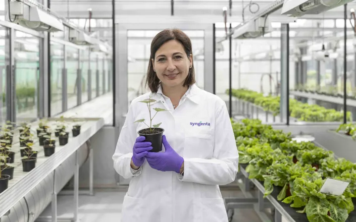 Camilla Corsi in greenhouse holding plant